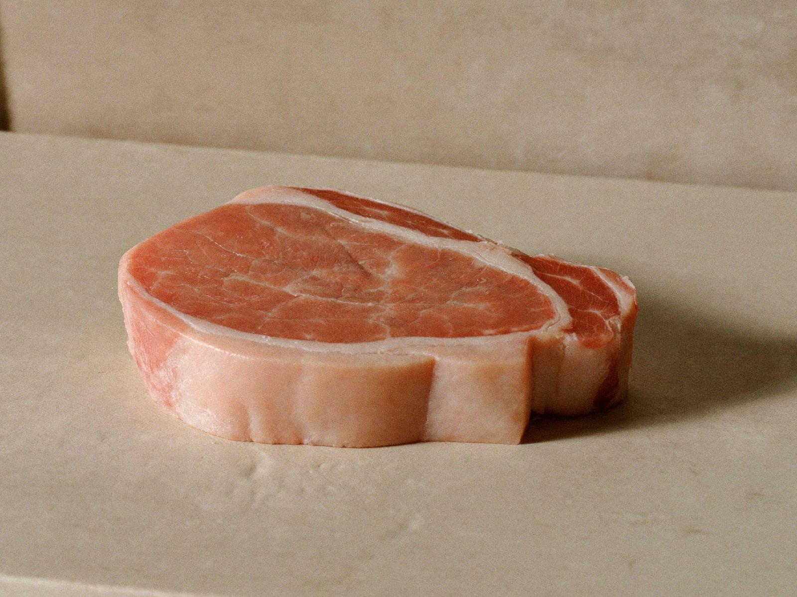 Chuleta de cerdo fresca sobre superficie de piedra clara
