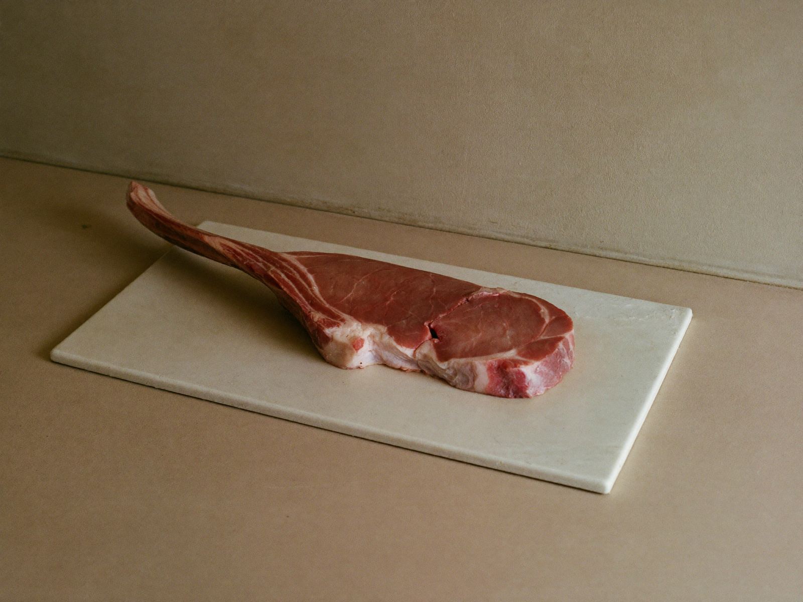 Tomahawk de cerdo fresco sobre superficie de piedra clara